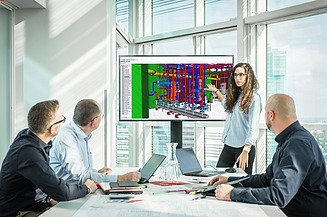 Person präsentiert einen farbigen 3D‑Gebäudetechnik‑Plan